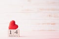 Valentines day concept. February 14 text on wooden block with handmade red heart on white wooden background Royalty Free Stock Photo