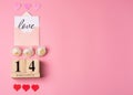 Valentines Day concept. February 14 wooden calendar, greeting card with the inscription love, pink and red hearts Royalty Free Stock Photo