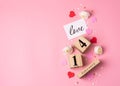 Valentines Day concept. February 14 wooden calendar, greeting card with the inscription love, pink and red hearts