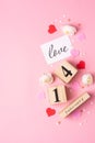 Valentines Day concept. February 14 wooden calendar, greeting card with the inscription love, pink and red hearts Royalty Free Stock Photo