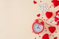 Flat lay photo of gift box, red hearts garland, heart shaped alarm clock, inscription love you