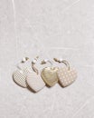 Valentines day concept. Four soft toy hearts from linen cloth with golden color striped or dots on grey marble table