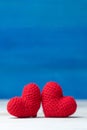 Valentines day concept. hand make two yarn red heart on wooden table and blue background Royalty Free Stock Photo