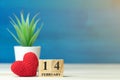 Valentines day concept. hand make yarn red heart beside wooden block calendar set on Valentines date 14 February in front of white Royalty Free Stock Photo