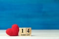 Valentines day concept. hand make yarn red heart beside wooden block calendar set on Valentines date 14 February on wooden table a Royalty Free Stock Photo