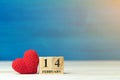 Valentines day concept. hand make yarn red heart beside wooden block calendar set on Valentines date 14 February on wooden table a Royalty Free Stock Photo