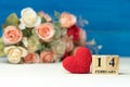 Valentines day concept. hand make yarn red heart beside wooden block calendar set on Valentines date 14 February in front of rose Royalty Free Stock Photo