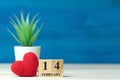 Valentines day concept. hand make yarn red heart beside wooden block calendar set on Valentines date 14 February in front of white Royalty Free Stock Photo