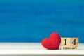 Valentines day concept. hand make yarn red heart beside wooden block calendar set on Valentines date 14 February on wooden table a Royalty Free Stock Photo