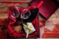 Valentines day. Red wine bottle, glasses and a gift in a box, wooden background Royalty Free Stock Photo