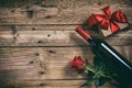 Valentines day. Red wine bottle, rose and a gift on wooden background Royalty Free Stock Photo