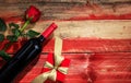 Valentines day. Red wine bottle, rose and a gift on wooden background Royalty Free Stock Photo