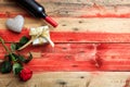 Valentines day. Red wine bottle, rose and a gift on wooden background Royalty Free Stock Photo