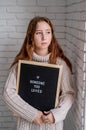 Sad beautiful woman holding felt letter board with the words Someone You Loved Royalty Free Stock Photo