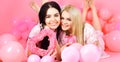 Valentines day concept. Sisters, friends in pajamas at pajamas party. Blonde and brunette on smiling faces dreaming