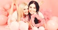 Valentines day concept. Sisters, friends in pajamas at pajamas party. Blonde and brunette on smiling faces dreaming