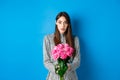 Valentines day concept. Surprised girlfriend receiving beautiful bouquet of flowers and looking with disbelief at camera Royalty Free Stock Photo