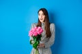 Valentines day concept. Surprised happy girl looking aside with amazement, receiving bouquet of romantic flowers Royalty Free Stock Photo