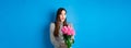 Valentines day concept. Surprised happy girl looking aside with amazement, receiving bouquet of romantic flowers Royalty Free Stock Photo