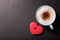 Valentines day. Cup of cappuccino coffee and colorful heart shaped cookie, top view