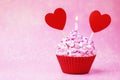 Valentines day cupcake. Cupcake with pink cream and sprinkled, with red heart and sparkler on a pink background with bokeh. Royalty Free Stock Photo