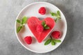 Valentines day dessert. heart shaped raw vegan red cake with raspberries and mint in a plate. healthy delicious food Royalty Free Stock Photo