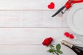 Valentines day dinner romantic festive setting, red tape, kraft gift box, champagne wine glass, bottle, roses, hearts Royalty Free Stock Photo
