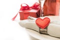 Valentines day dinner with table place setting with red gift, heart with silverware on white background. Close up. Valentine`s ca Royalty Free Stock Photo