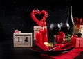 Valentines day dinner with table setting with gift, red roses, hearts with two wineglasses