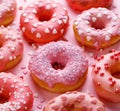 Valentines day donuts with icing and sugar sprinkles on a pink backgValentine`s Day hot chocolate with heart-shaped marshmallows.