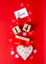 Valentines Day. February 14 wooden calendar, greeting card with the inscription love, pink and red hearts, flowers on a red Royalty Free Stock Photo