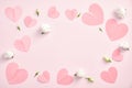 Valentines day flat lay composition. Top view pink paper hearts and white buds of rose flowers on pastel pink background. Minimal Royalty Free Stock Photo