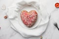 Festive heart shaped cake on plate.