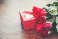 Valentines day gift box flower love concept Red gift box with ribbon bow red roses flower on wooden table Royalty Free Stock Photo