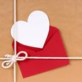 Valentines day gift with white heart shape card, red envelope, brown paper package parcel background Royalty Free Stock Photo