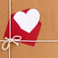 Valentines day gift with white heart shape card, red envelope, brown paper package parcel background Royalty Free Stock Photo