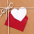 Valentines day gift with white heart shape card, red envelope, brown paper package parcel background Royalty Free Stock Photo