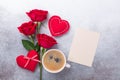 Valentines day greeting card. Coffee cup, red roses and textile heart on stone background. Top view Royalty Free Stock Photo