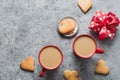 Valentines day greeting card with heart cookies, gift, coffee cup on grey table.