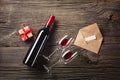 Valentines day greeting card. Red wine, gift box and glasses on wooden table. View with space for your greetings Royalty Free Stock Photo