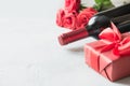 Valentines day greeting card with romantic red roses, bottle of red wine on white. Space for text. Close up Royalty Free Stock Photo