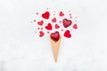 Valentines day greeting concept with waffle cone and mixed red hearts on white background top view. Fashion flat lay.