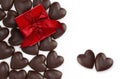 Valentines day, heart shaped chocolates with wrapped glittering red box and shiny ribbon bow isolated on white background, layout Royalty Free Stock Photo