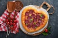 Valentines day heart shaped pizza with mozzarella, pepperoni and basil, wine bottle, two wineglass, gift box on black background. Royalty Free Stock Photo