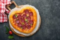 Valentines day heart shaped pizza with mozzarella, pepperoni and basil, wine bottle, two wineglass, gift box on black background. Royalty Free Stock Photo