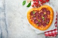 Valentines day heart shaped pizza with mozzarella, pepperoni and basil, wine bottle, two wineglass, gift box on light grey backgro Royalty Free Stock Photo