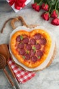 Valentines day heart shaped pizza with mozzarella, pepperoni and basil, wine bottle, two wineglass, gift box on light grey Royalty Free Stock Photo