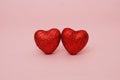Valentines Day hearts - two Red Hearts, Glitter on Shiny, Sparkle on Pink Background