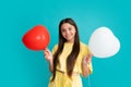 Valentines day and kids concept. Teenage girl in yellow dress with red heart-shaped balloon over blue background. Happy Royalty Free Stock Photo