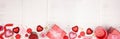Valentines Day long banner border with red gifts and decorations over a white wood background with copy space